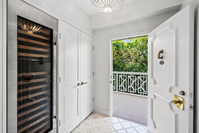 doorway featuring an inviting chandelier and wine cooler