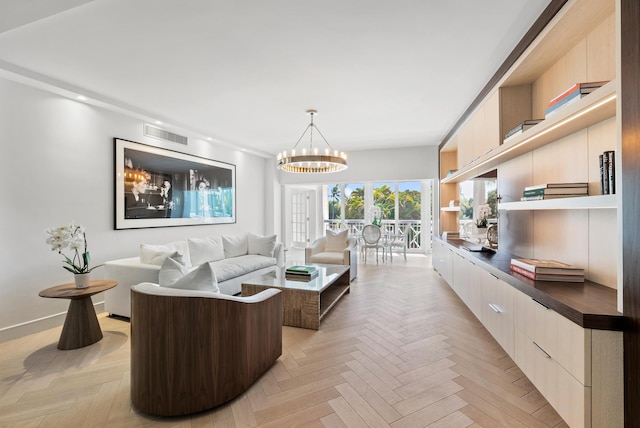 living room with light parquet flooring and an inviting chandelier