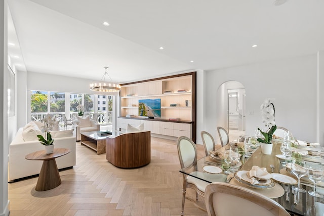 living room featuring light parquet flooring and a notable chandelier