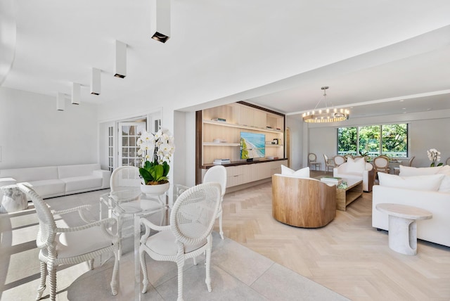 living room with light parquet floors and an inviting chandelier