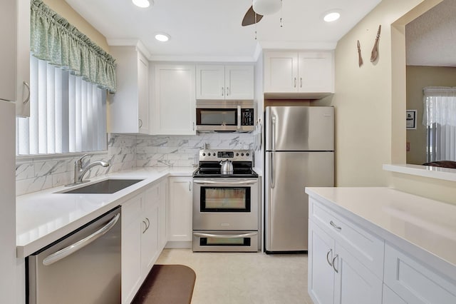 kitchen featuring a sink, appliances with stainless steel finishes, and white cabinets