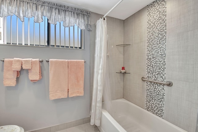 full bath featuring shower / bath combination with curtain and baseboards