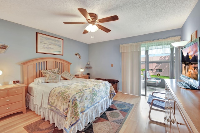 bedroom with light wood-type flooring, a textured ceiling, access to exterior, and a ceiling fan