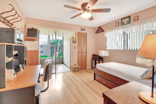 bedroom with wood finished floors, ceiling fan, a closet, a textured ceiling, and access to outside