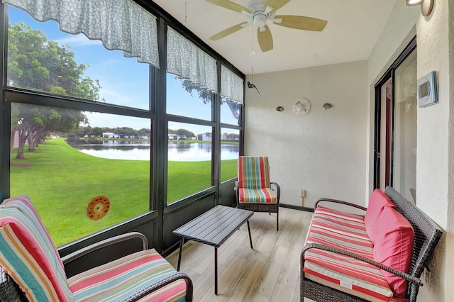 sunroom / solarium featuring ceiling fan and a water view