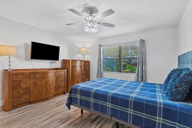 bedroom featuring wood-type flooring, a textured ceiling, and ceiling fan