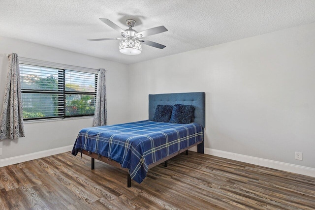 bedroom featuring ceiling fan, a textured ceiling, and dark wood-type flooring