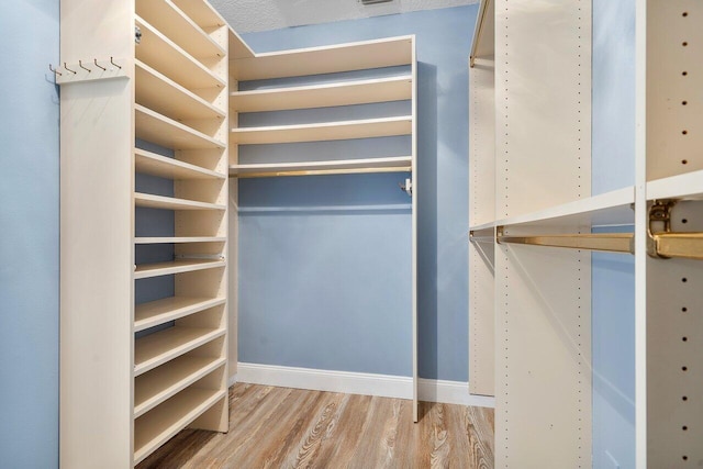 walk in closet with wood-type flooring