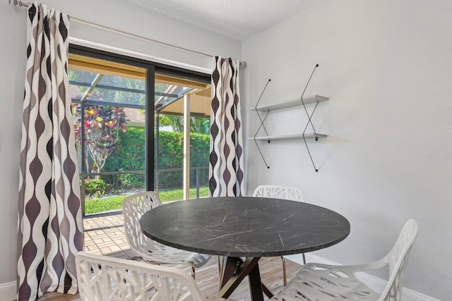 dining space featuring a textured ceiling and wood-type flooring