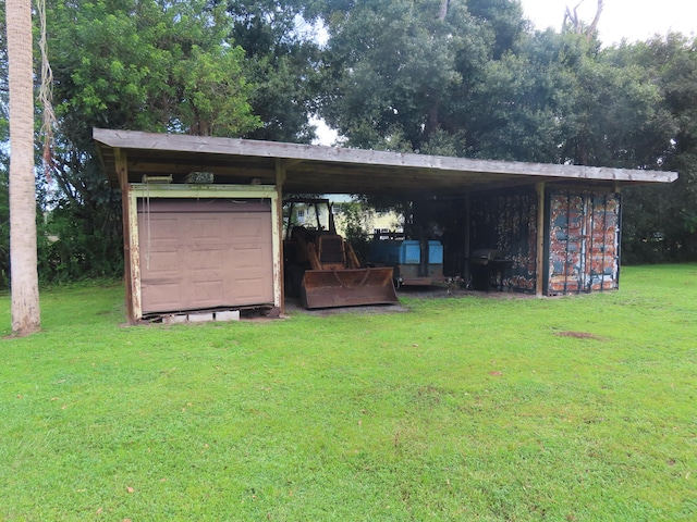 rear view of property featuring a lawn, a storage unit, and a carport