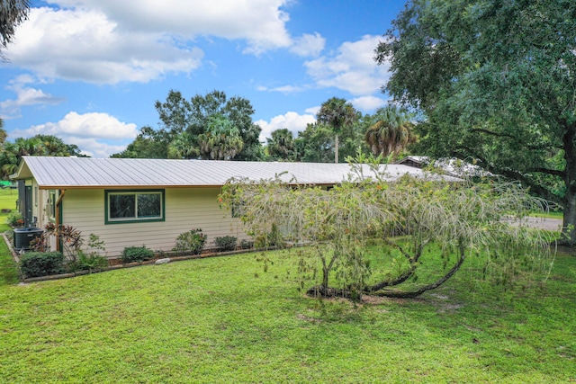 view of side of property with a lawn and central AC unit