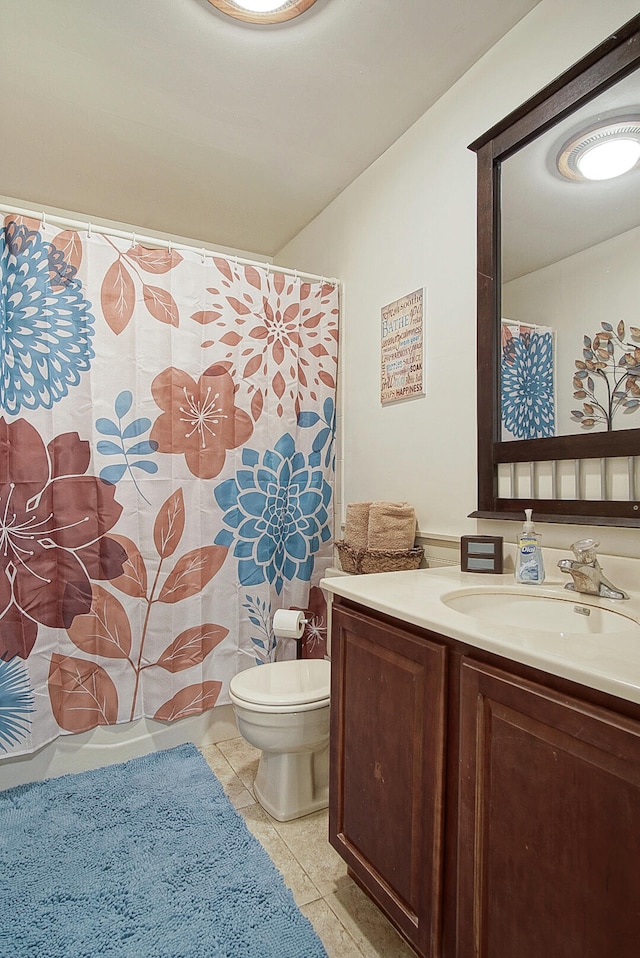 bathroom featuring curtained shower, vanity, toilet, and tile patterned floors