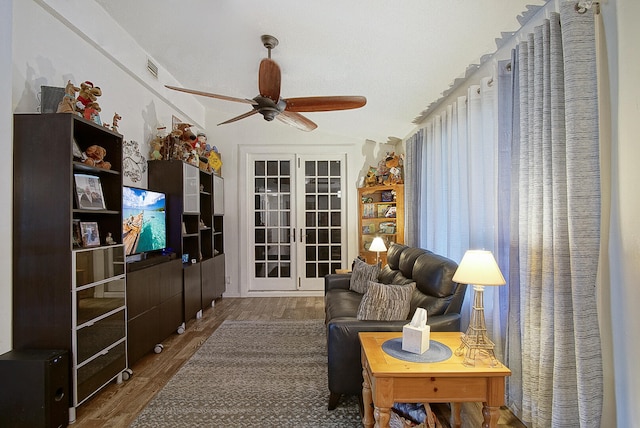 living room with a textured ceiling, wood-type flooring, lofted ceiling, ceiling fan, and french doors