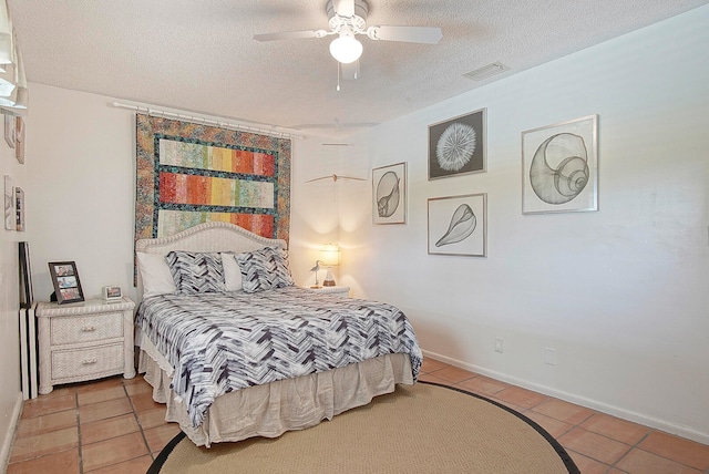 tiled bedroom featuring ceiling fan and a textured ceiling