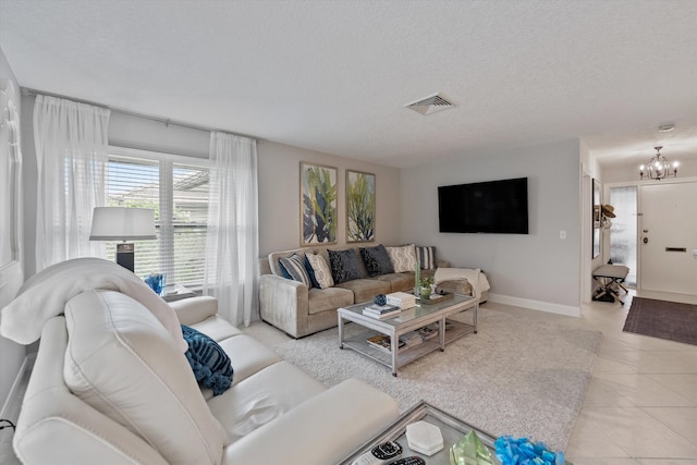 tiled living room featuring a textured ceiling and an inviting chandelier