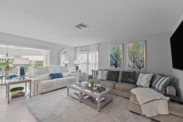 living room featuring light tile patterned floors, a chandelier, and a textured ceiling