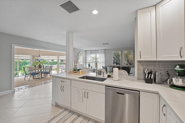 kitchen featuring white cabinetry, sink, light tile patterned floors, and stainless steel dishwasher