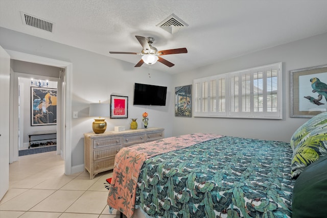 tiled bedroom with a textured ceiling and ceiling fan