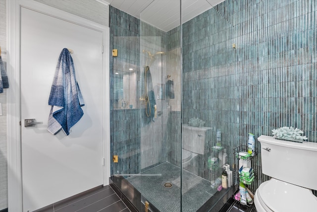 bathroom featuring tile patterned flooring, toilet, an enclosed shower, and tile walls