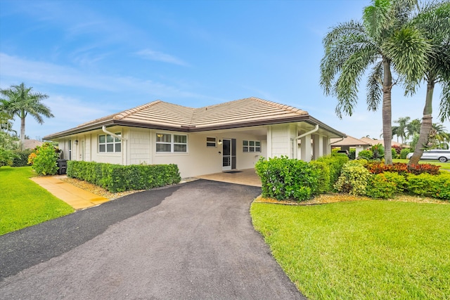 view of front of house with a front yard and a carport