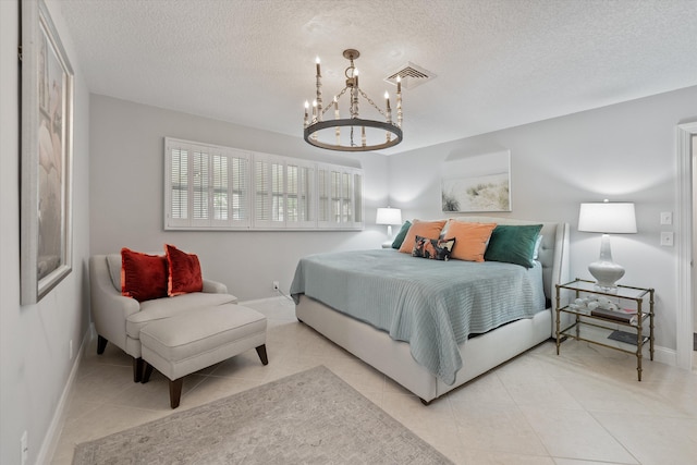 bedroom featuring light tile patterned flooring, a textured ceiling, and an inviting chandelier