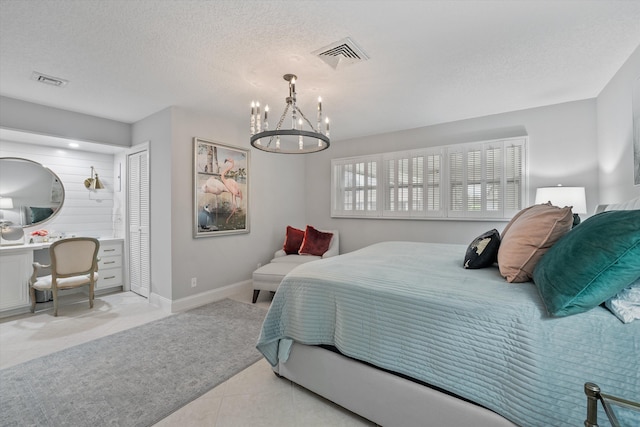 tiled bedroom featuring a chandelier, a textured ceiling, and a closet