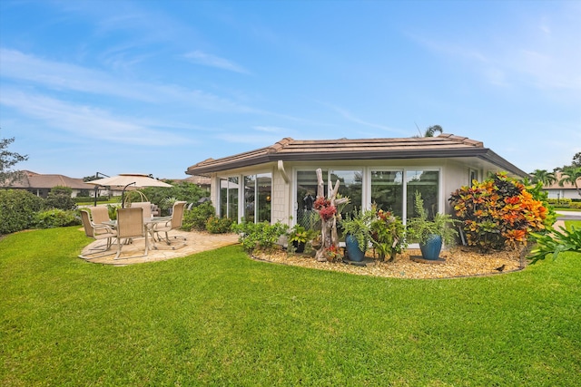 back of house with a lawn and a patio area