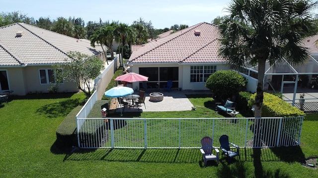 view of property's community featuring a yard, a patio, and a fire pit