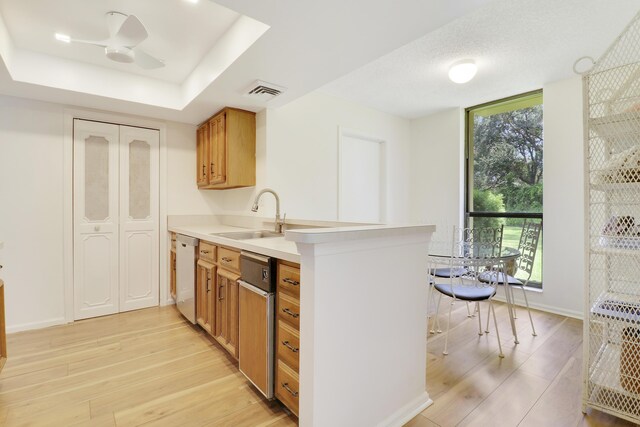 kitchen featuring ceiling fan, sink, light hardwood / wood-style flooring, and white dishwasher