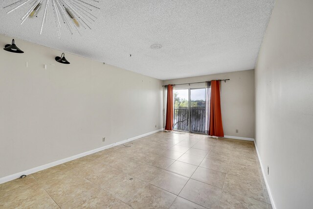 empty room featuring a textured ceiling and light tile patterned floors