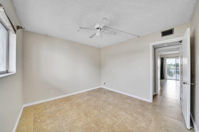 tiled spare room featuring ceiling fan and a textured ceiling