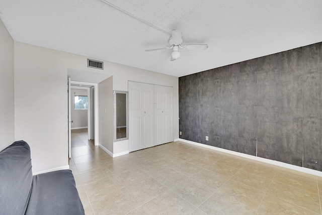 unfurnished bedroom featuring a closet, ceiling fan, and a textured ceiling