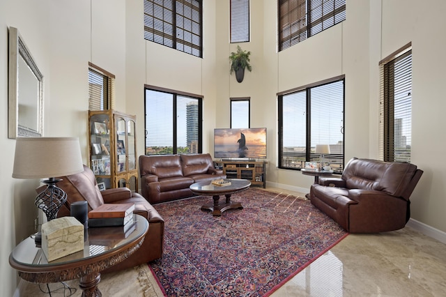 living room with a high ceiling and plenty of natural light