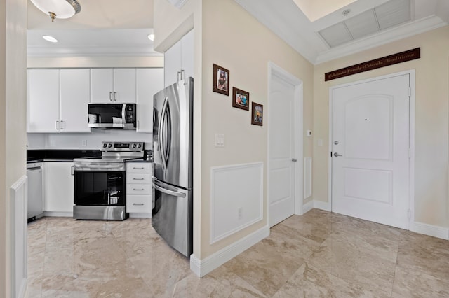 kitchen featuring appliances with stainless steel finishes, white cabinetry, and ornamental molding