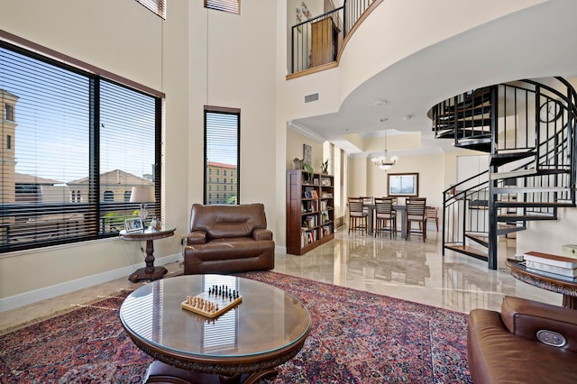 living room with a towering ceiling, an inviting chandelier, and plenty of natural light