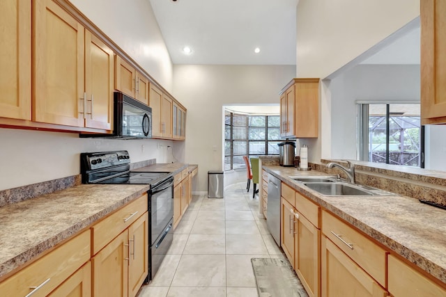 kitchen with vaulted ceiling, black appliances, sink, and a wealth of natural light