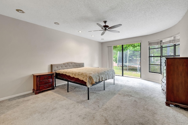 carpeted bedroom featuring a textured ceiling, access to exterior, and ceiling fan