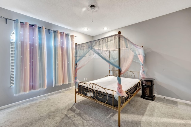 carpeted bedroom with ceiling fan and a textured ceiling