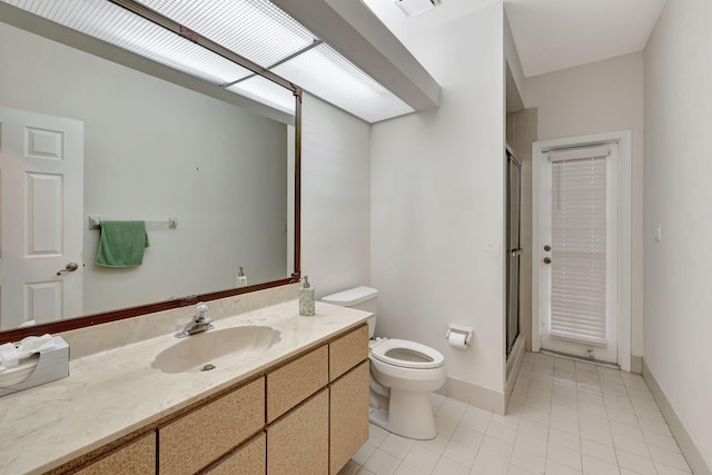 bathroom featuring toilet, walk in shower, vanity, and tile patterned flooring