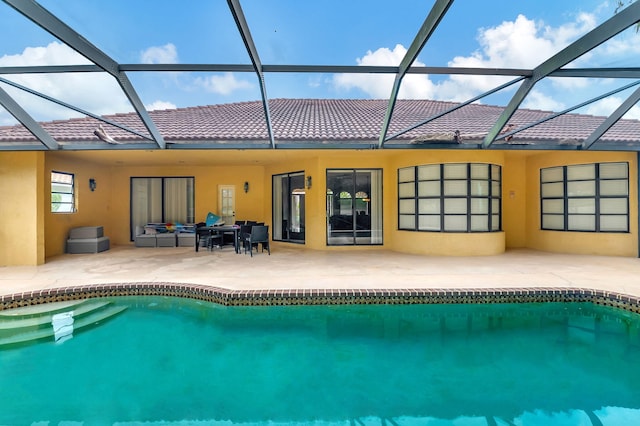 rear view of house featuring a patio and glass enclosure