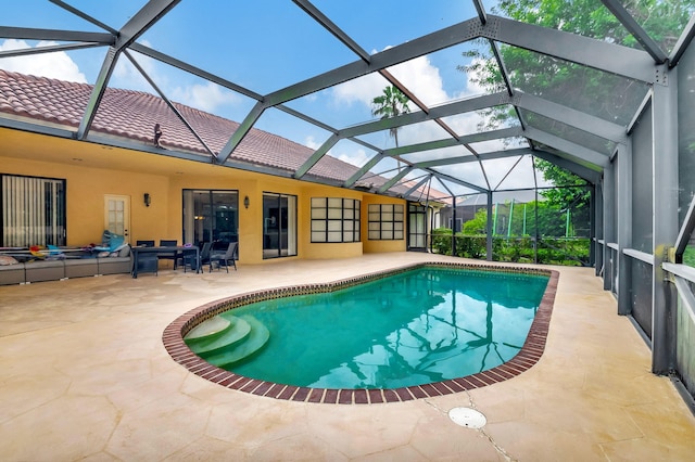 view of pool with a patio and glass enclosure