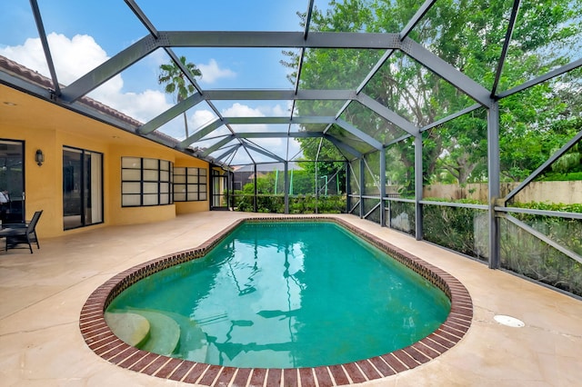 view of pool with a patio and a lanai