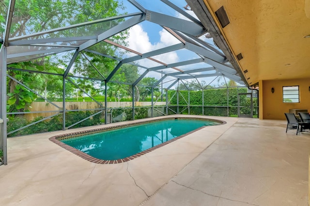 view of swimming pool featuring a patio and glass enclosure