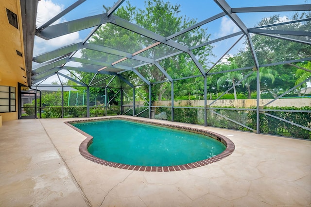 view of swimming pool with a patio and glass enclosure