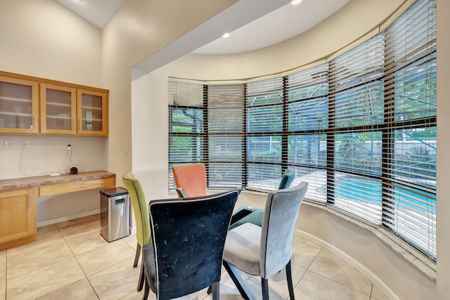 dining area featuring built in desk and light tile patterned floors