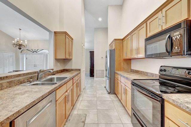 kitchen with light tile patterned floors, an inviting chandelier, black appliances, sink, and decorative light fixtures