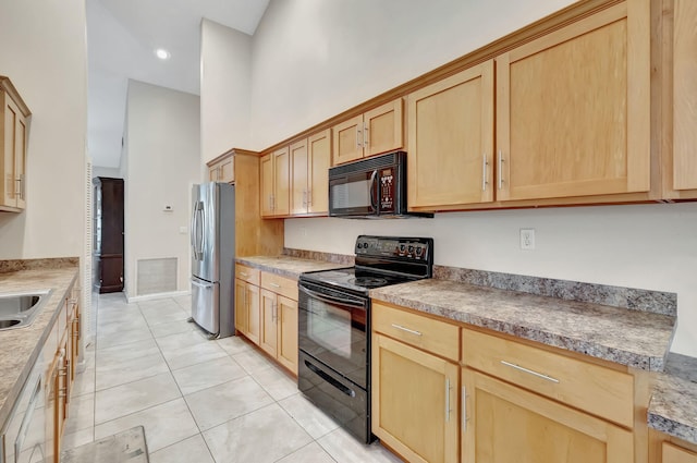 kitchen featuring light tile patterned floors, light brown cabinetry, black appliances, a high ceiling, and sink