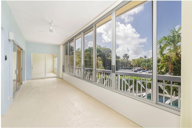 unfurnished sunroom with ceiling fan and a healthy amount of sunlight