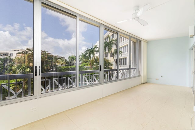 unfurnished sunroom with ceiling fan