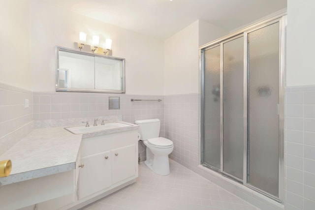 bathroom featuring vanity, tile walls, tile patterned flooring, and a shower with shower door